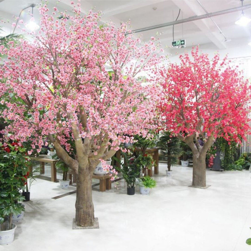 Top rated artificial blossom trees in vibrant pink and red with lifelike trunks and secure square bases in a Lahore showroom | The Fast Interior Studio