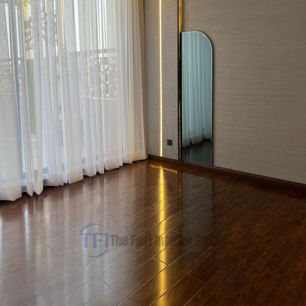 A bright room in Lahore featuring highly reflective, high-gloss Chaina Floor 12 MM rosewood laminate seamlessly installed next to floor-to-ceiling sheer curtains