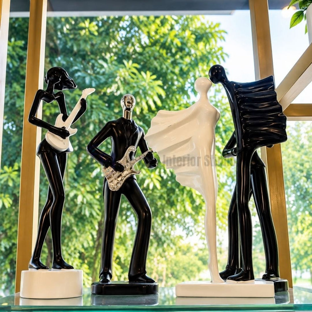 A collection of 5-inch modern abstract sculptures including guitarists and a romantic couple, styled on a glass shelf for versatile luxury decor