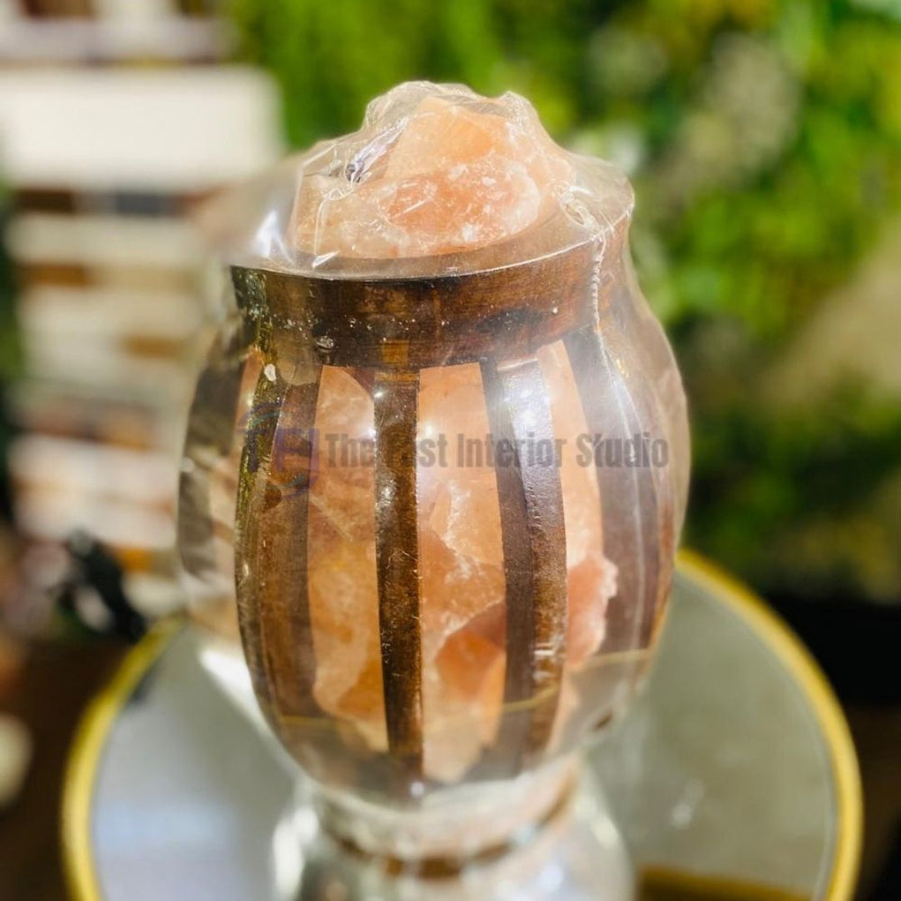 A contemporary Himalayan salt lamp featuring raw pink salt chunks housed inside a flared chalice-shaped black metal frame