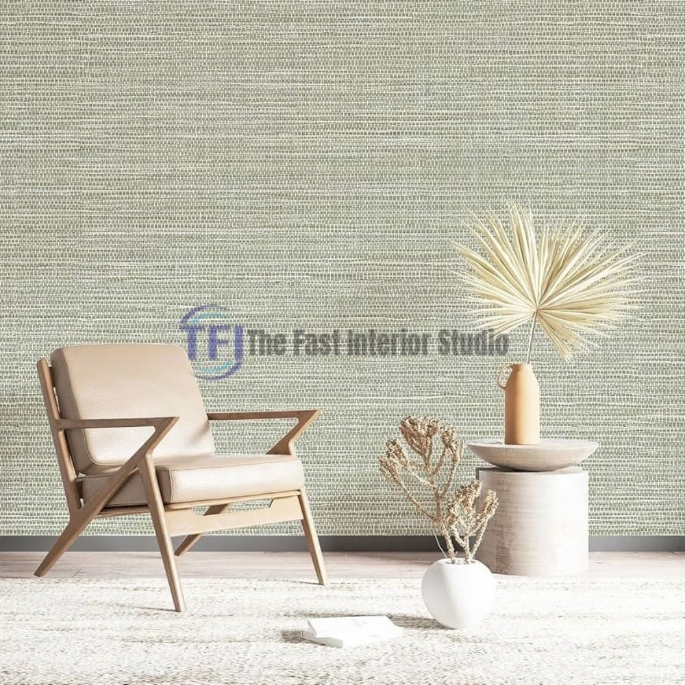 A cozy reading corner featuring a gray jute wallpaper accent wall styled with a modern wooden armchair, a side table with dried palm leaves, and a textured rug