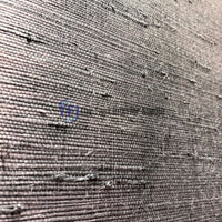 A detailed macro view showcasing the intricate horizontal fibers and dark gray woven texture of a jute wallpaper installation