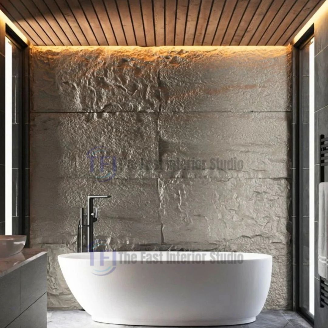A luxury modern bathroom featuring a freestanding white bathtub set against a highly textured rustic sandstone PU faux stone feature wall, illuminated by warm ceiling lights