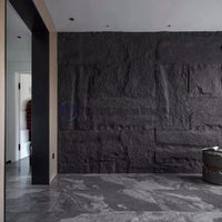 A modern interior hallway featuring an expansive, deeply textured dark charcoal 3D PU large block faux stone feature wall