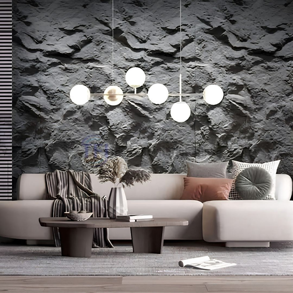 A modern living room featuring a massive dark grey 3D PU cliff rock feature wall behind a white sofa, illuminated by a contemporary globe pendant light