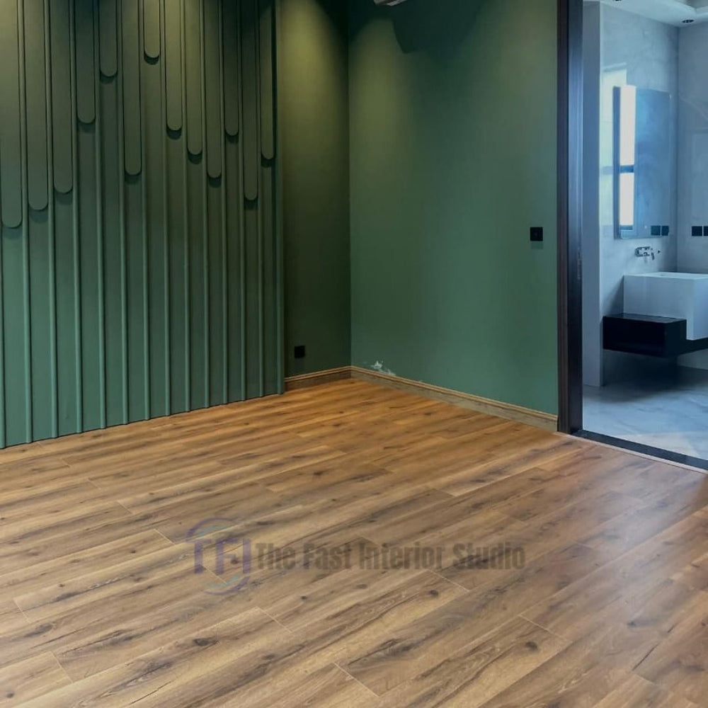 A modern room featuring a bold dark green slatted accent wall, perfectly grounded by seamless, medium brown Chaina Floor 12 MM wood laminate flooring