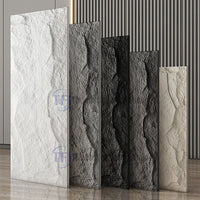 A premium showroom display featuring five vertical 3D PU chiseled rock wall panels arranged in a gradient of colors including white, light grey, dark grey, black, and warm beige