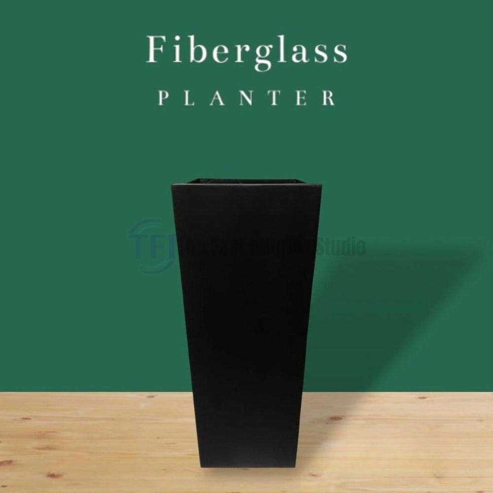 A premium tall, tapered square fiberglass planter in a matte black finish, styled for luxury indoor and outdoor botanical decor