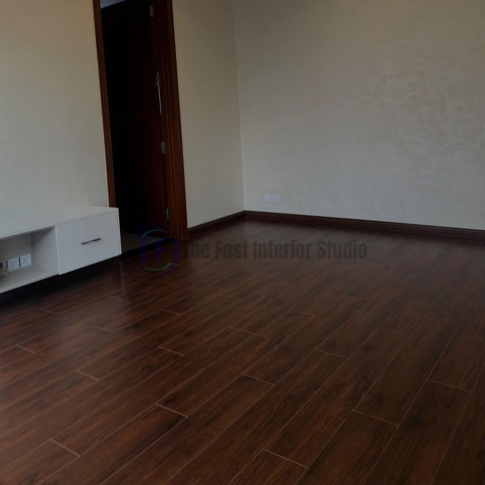 A room featuring deep dark walnut Chaina Floor 12 MM laminate flooring, providing a strong contrast against light walls and a modern white console unit