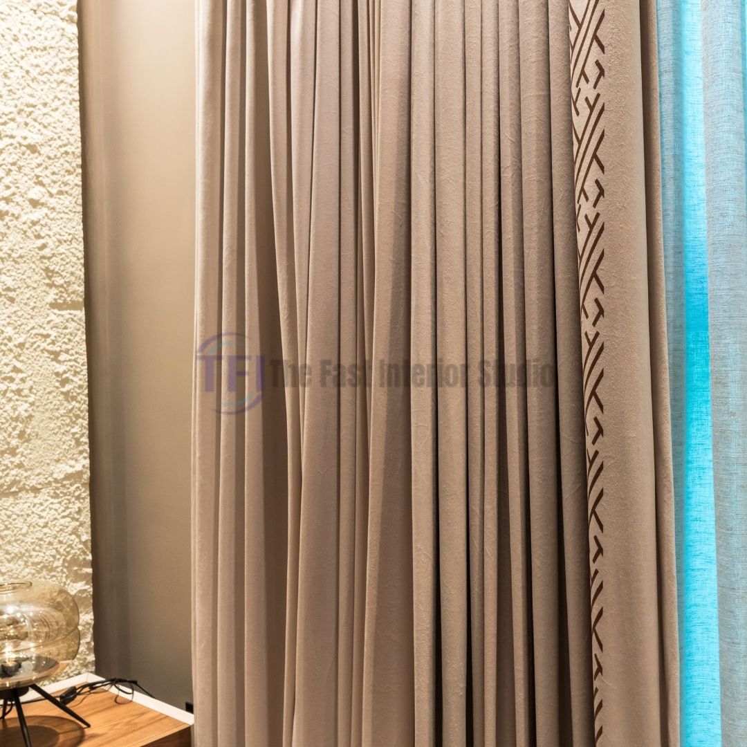 Close-up of beige drapes with patterned trim and blue inner curtains