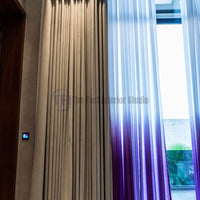 Close-up of pleated grey drapes and purple ombre sheer curtains