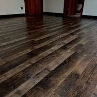 Close-up view of Chaina Floor 12 MM multi-tone laminate flooring highlighting its dramatic contrast of dark browns, weathered greys, and highly pronounced grain patterns