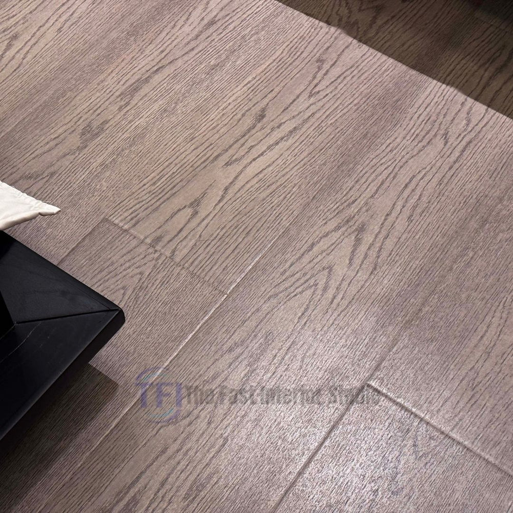 Close-up view of premium AGT European grey wood laminate flooring, highlighting its highly authentic, pronounced grain texture and seamless plank joints