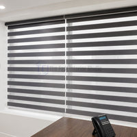 Dark charcoal zebra blinds over office windows providing a professional and luxurious aesthetic