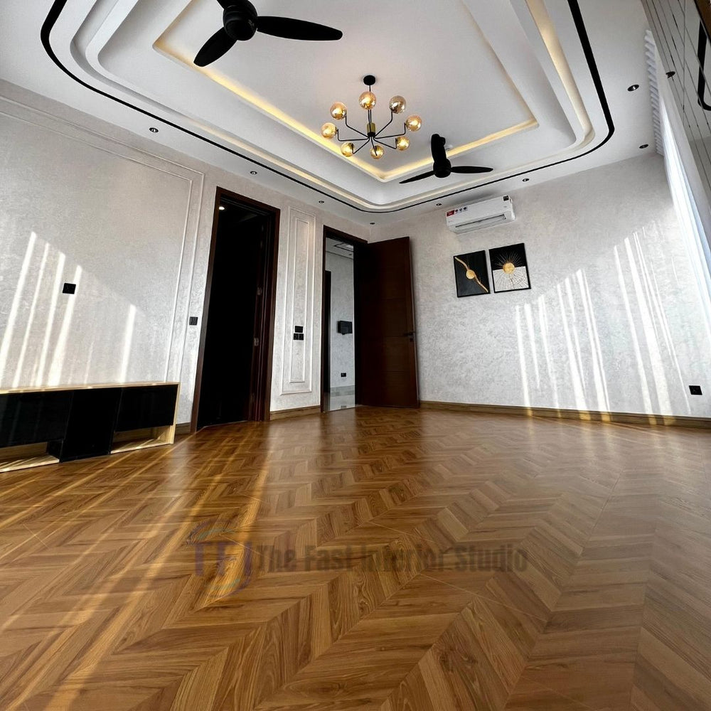 Expansive view of a modern living space grounded by stunning Chaina Floor 12 MM golden amber chevron wood laminate, reflecting natural sunlight beneath a contemporary chandelier