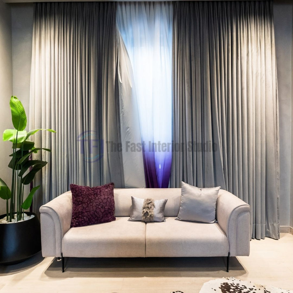 Grey outer curtains with a purple ombre sheer layer behind a sofa
