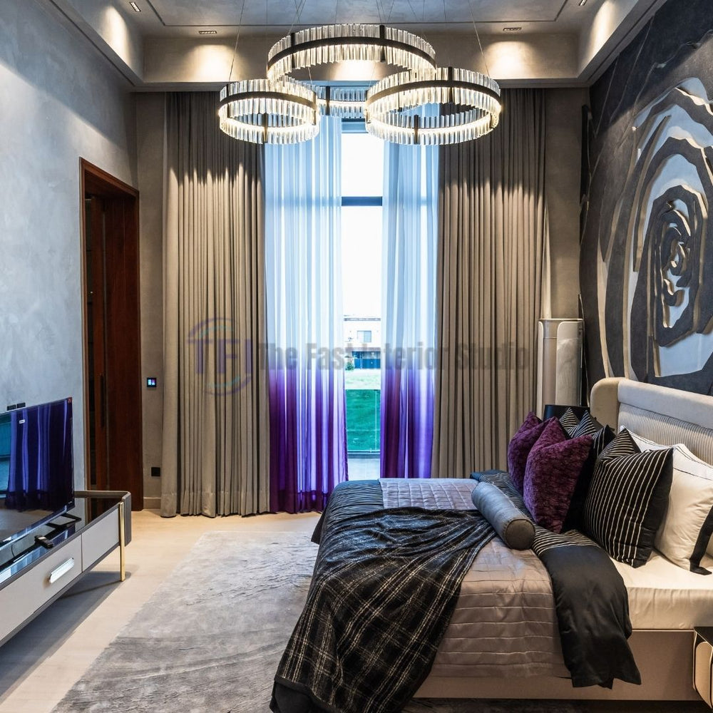 Layered grey and purple ombre bedroom curtains with a chandelier