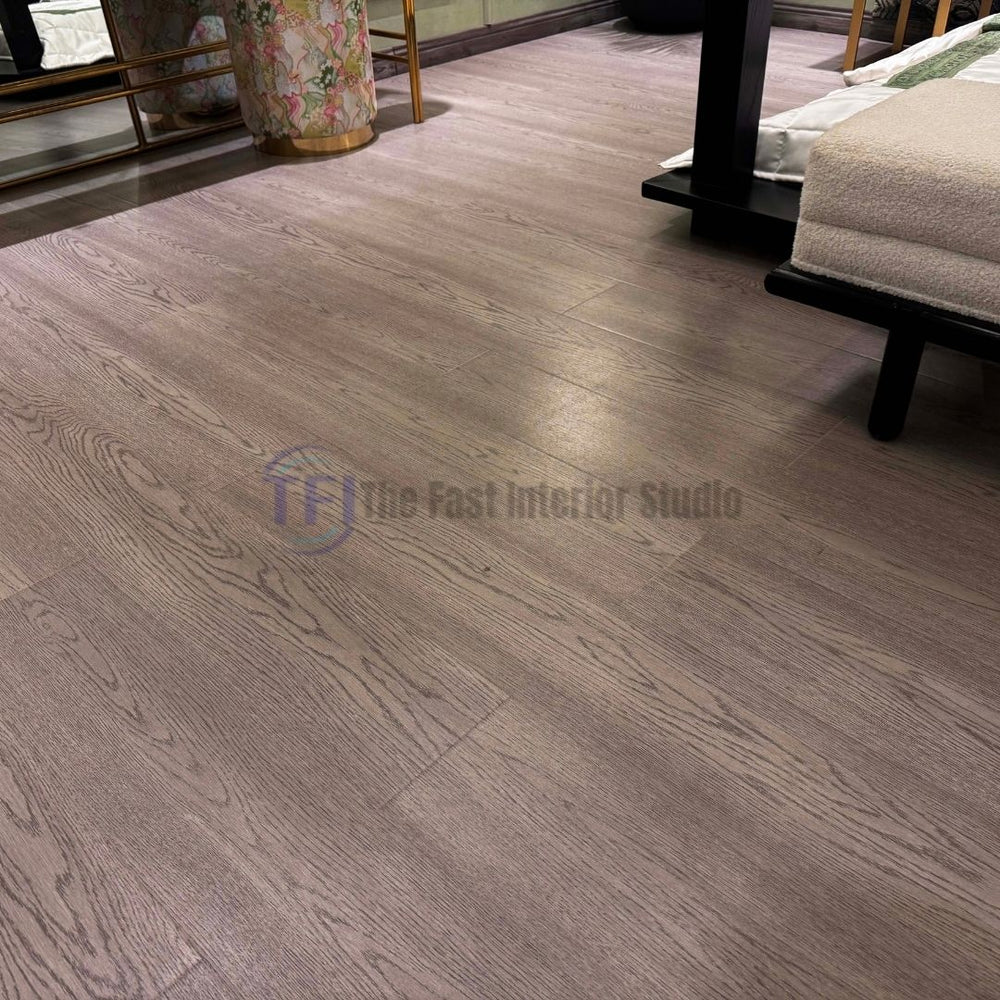 Medium grey wood laminate flooring with authentic grain textures installed next to a dark modern bed frame