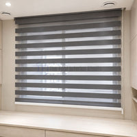 Modern grey Day & Night Zebra blinds installed in a room with light wood cabinetry | The Fast Interior Studio