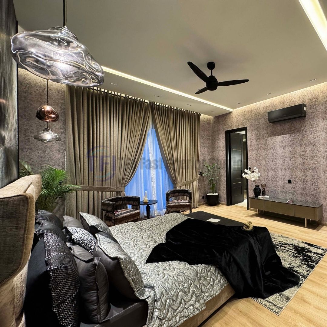 Pleated gold curtains and sheers in a moody bedroom with a glass pendant light