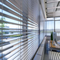 Sleek silver Venetian blinds installed along expansive glass windows in a modern office