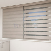 Soft beige dual roller shades on a standard window allowing adjustable natural light