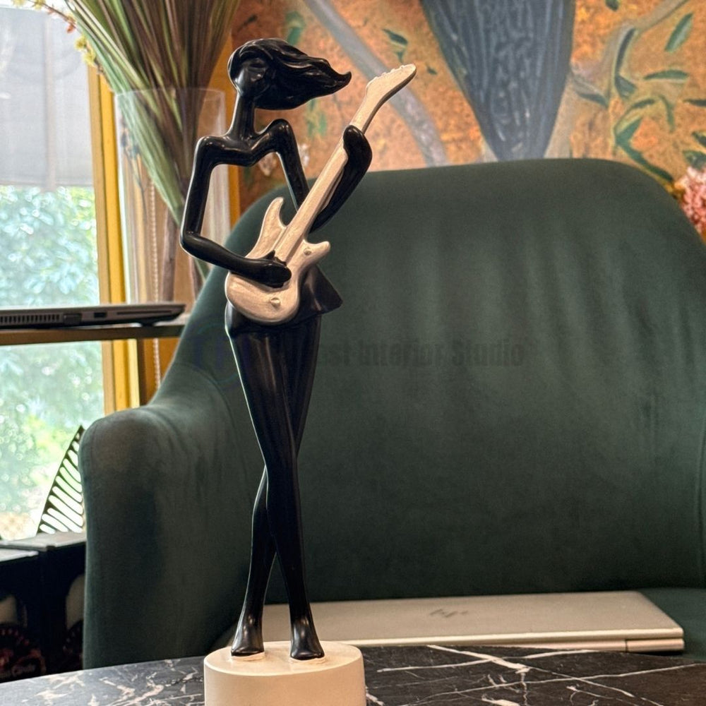The best black and silver abstract lady guitarist sculpture displayed on a marble table in a luxury interior