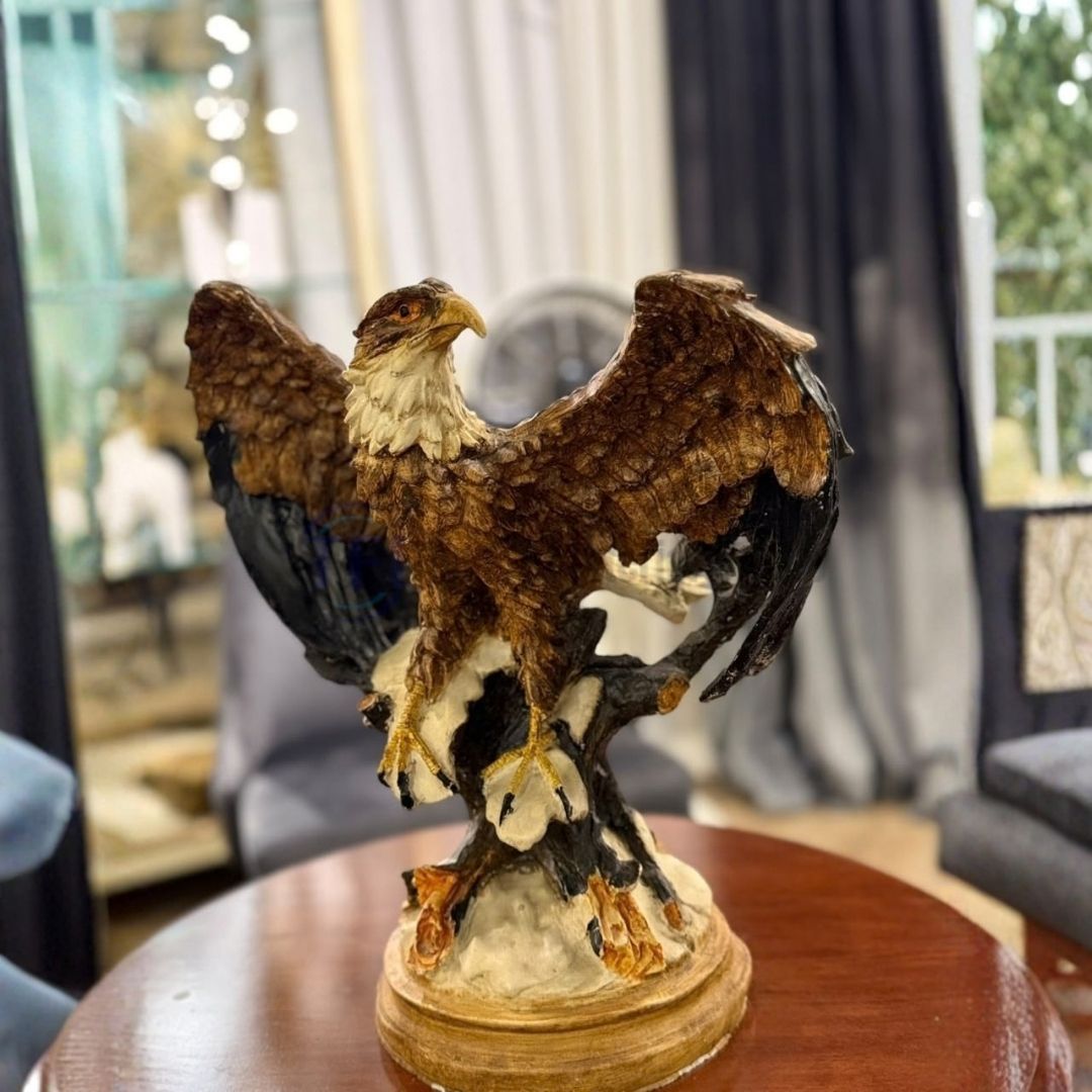 The best majestic eagle sculpture with spread wings perched on a branch, styled on a wooden round table for versatile luxury decor