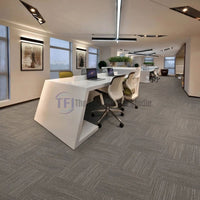 Top-rated light grey parquet-pattern carpet tiles seamlessly installed in a bright, open-plan commercial office space